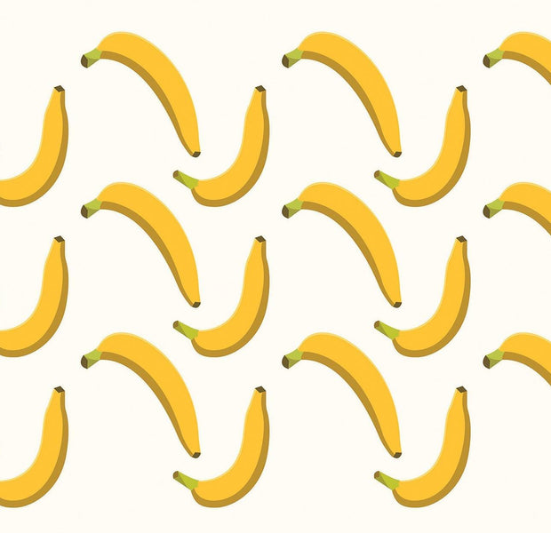 A playful wall mural featuring a repeating pattern of yellow bananas on a light background