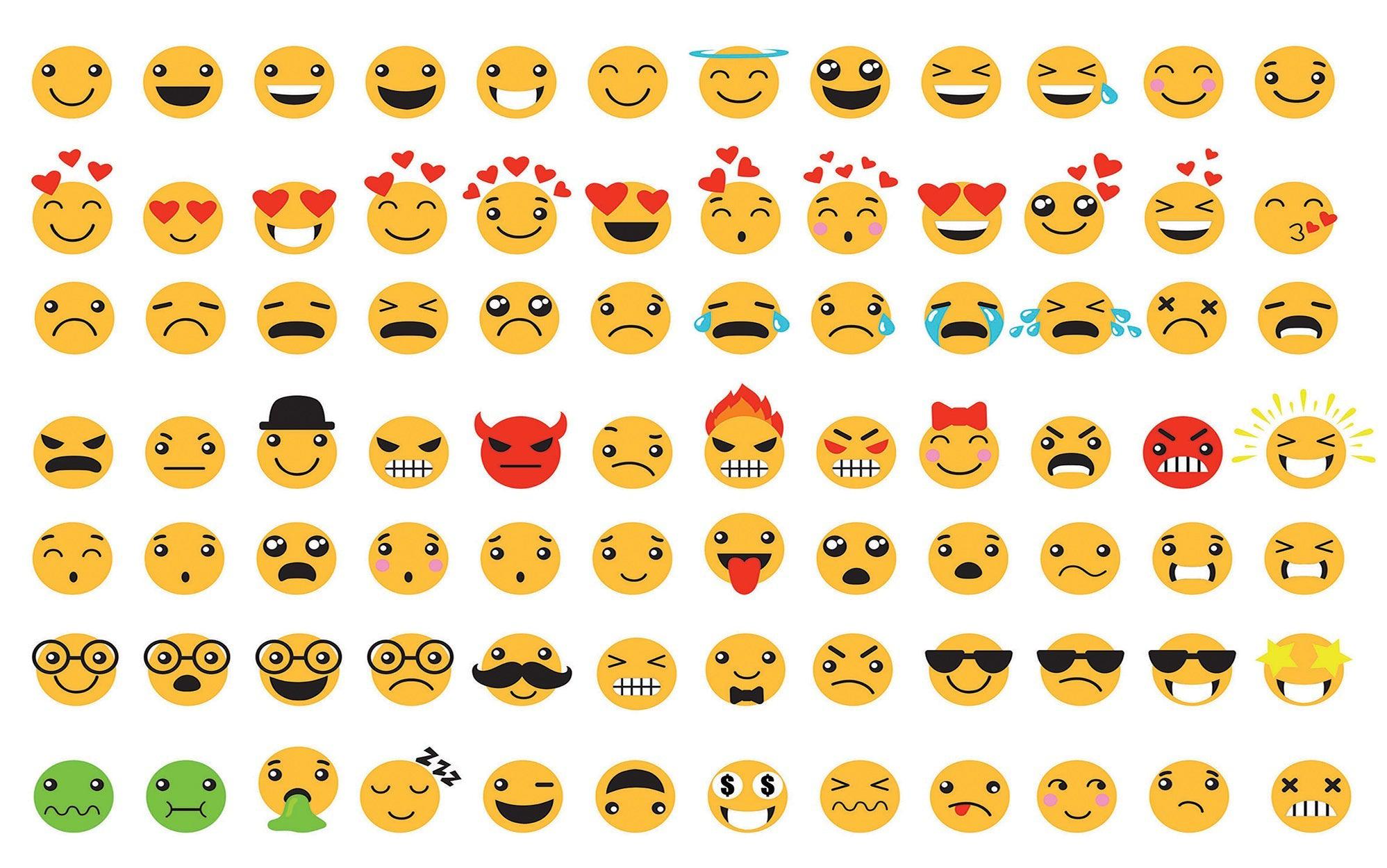 A large collection of various emoji icons arranged on a wall mural in an interior setting.