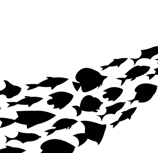 Black fish silhouettes forming a mural on a white wall for interior decoration