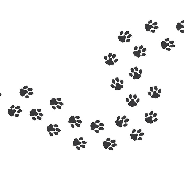 Black paw print pattern in diagonal layout on a white wall representing a wall mural