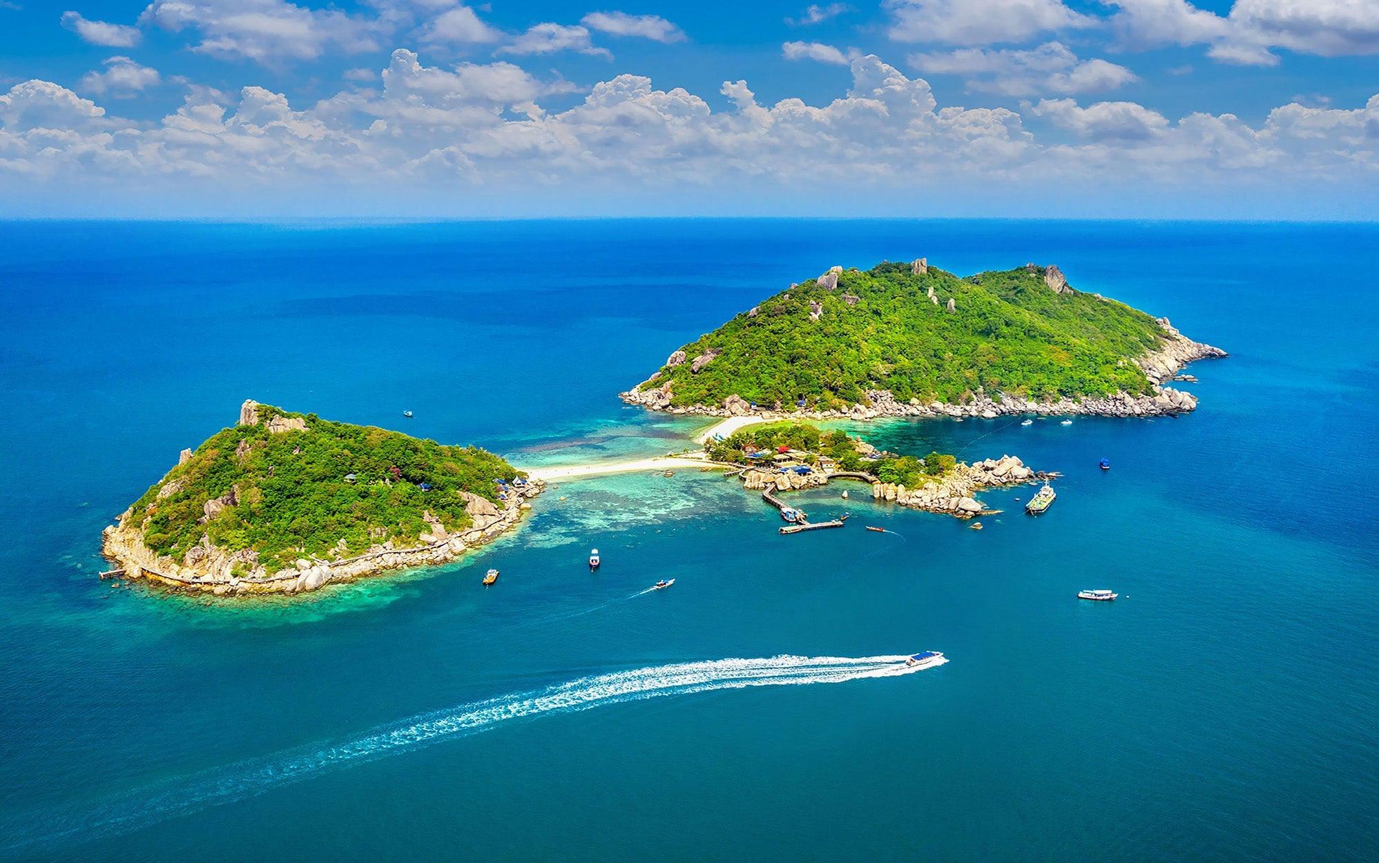 Aerial view of a tropical island with clear blue waters and boats