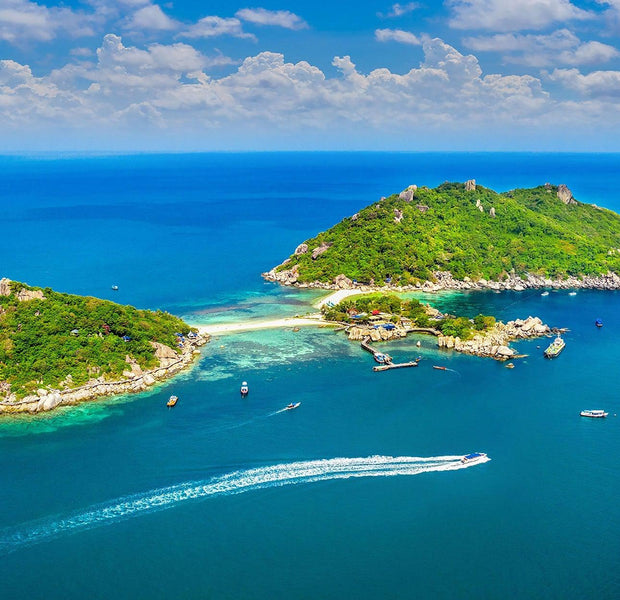 Aerial view of a tropical island with clear blue waters and boats
