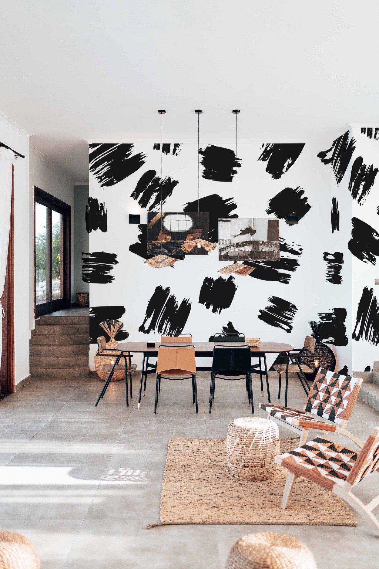 Stylish dining room interior with abstract black and white wall mural, contemporary furniture and natural light