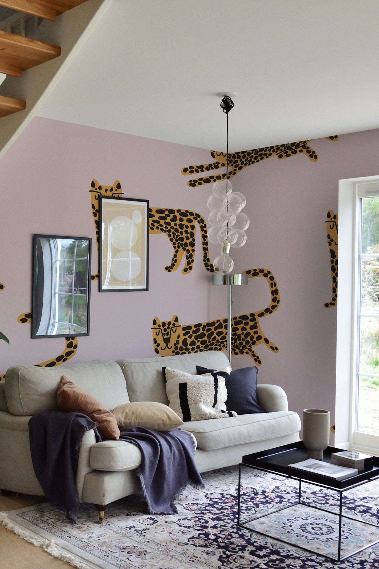 Modern living room interior with a creative wall mural of leopards, featuring a cozy sofa and stylish home decor