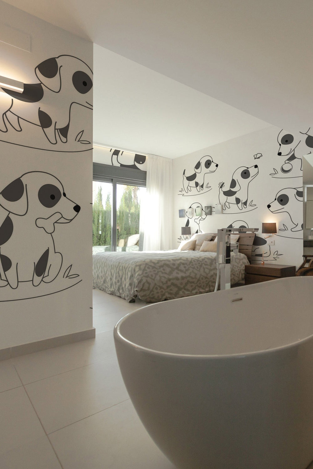 A spacious modern bedroom with a large dog-themed wall mural and a white freestanding bathtub in the foreground.