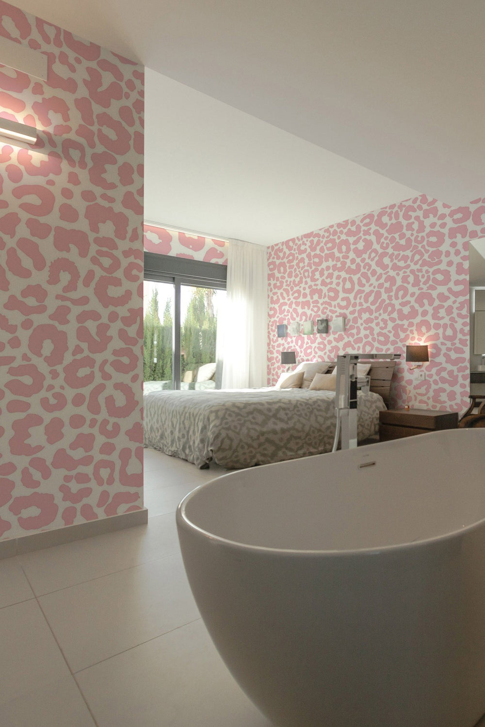 Stylish bedroom interior with pink animal print wall mural and a freestanding bathtub