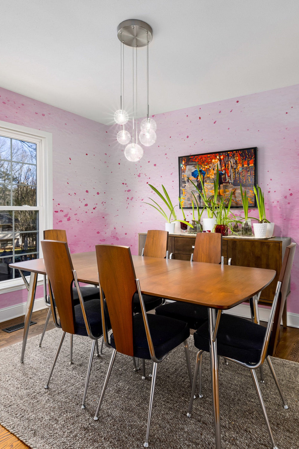 Stylish dining room with wooden table, mid-century modern chairs and an abstract wall mural with vibrant splashes of color