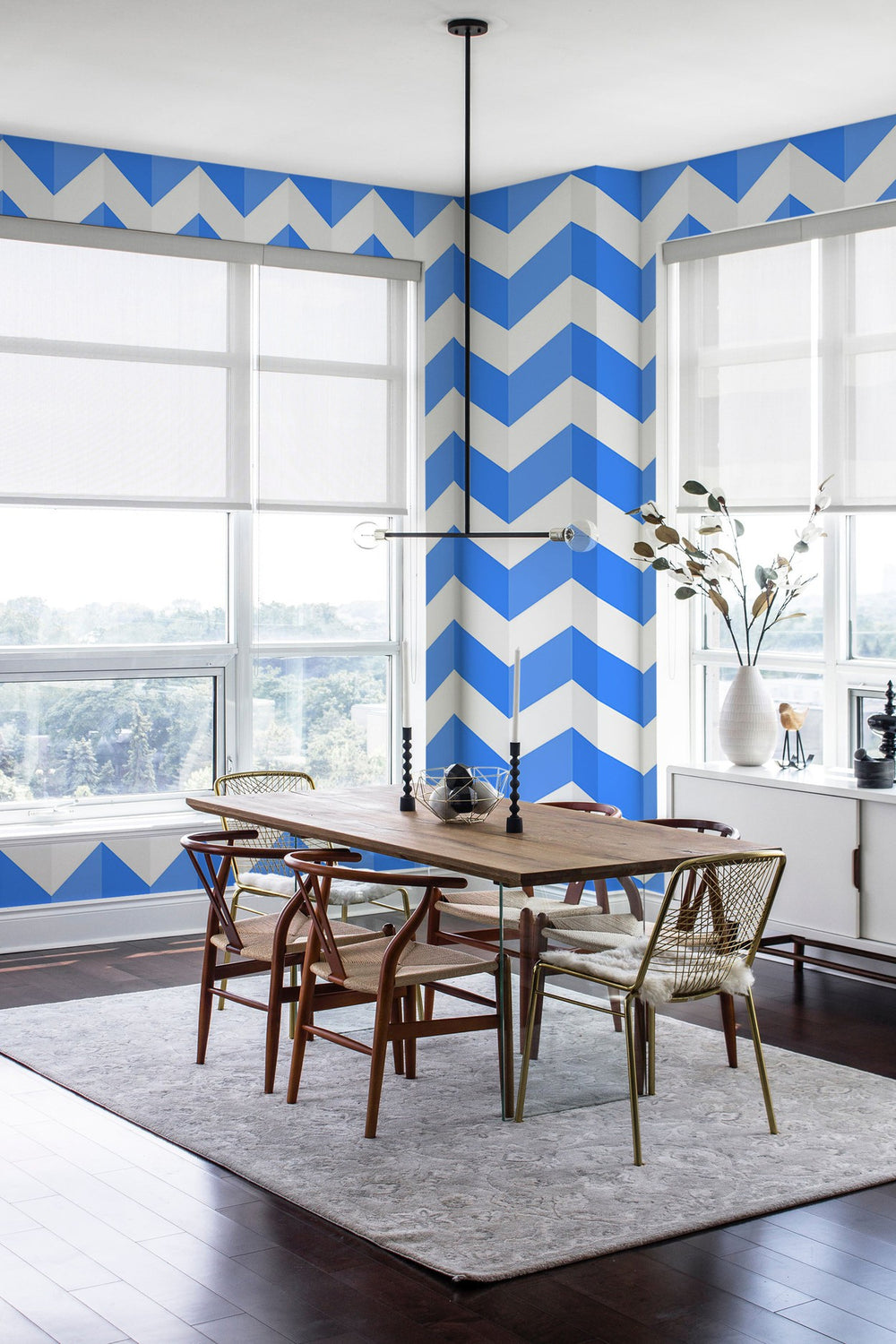 Contemporary dining room with a blue and white chevron pattern wall mural, wooden table, and stylish chairs.