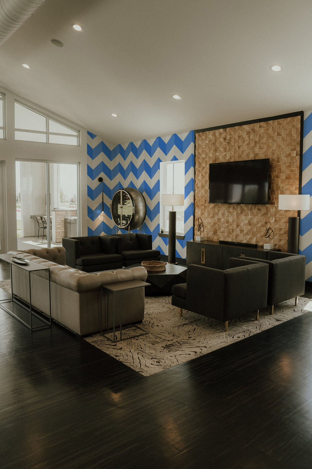 Stylish living room interior with a chevron pattern wall mural, comfortable seating and elegant decor.