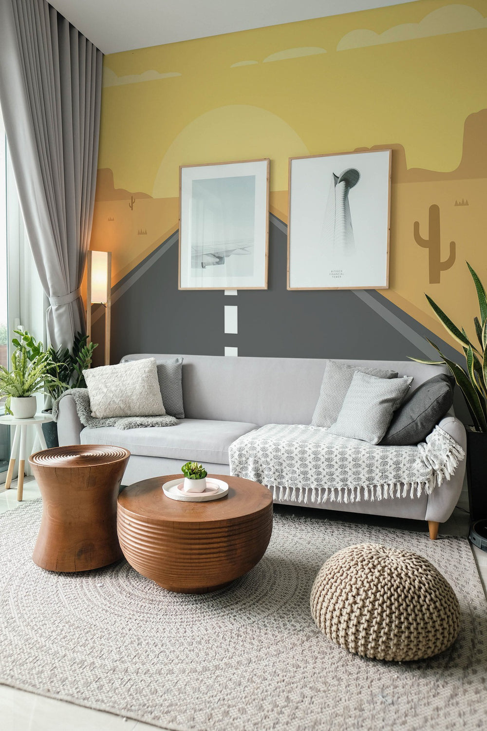 Contemporary living room interior with desert-themed wall mural, cozy grey sofa, and stylish wooden furniture
