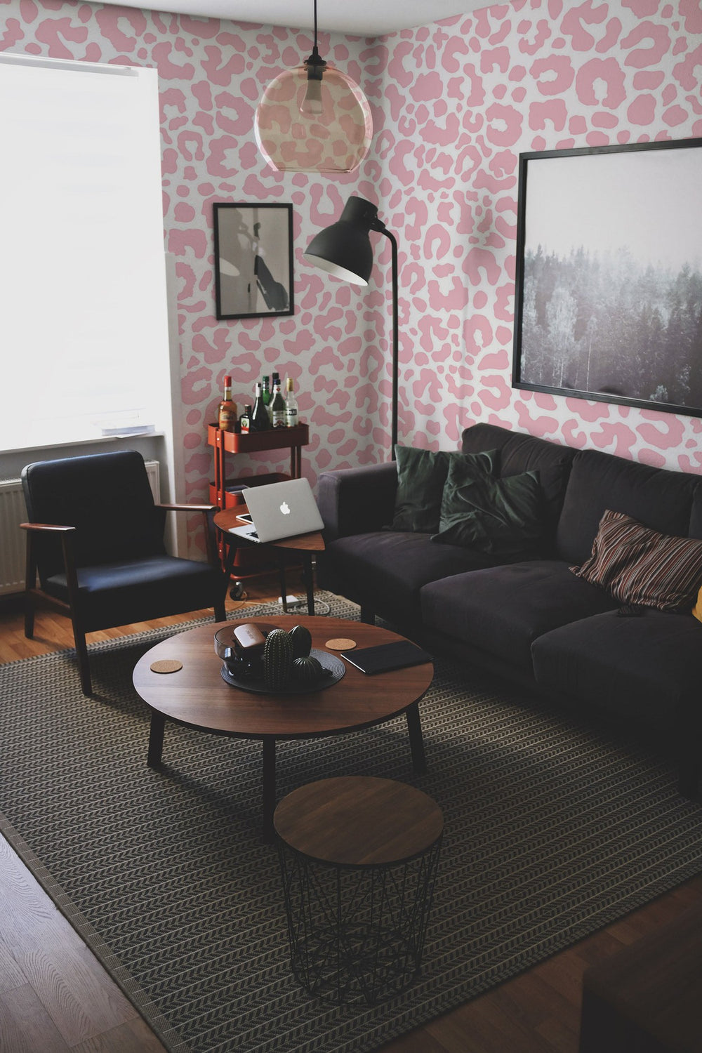 Interior of a modern living room featuring a sofa, coffee tables, and a wall mural with an abstract pattern.